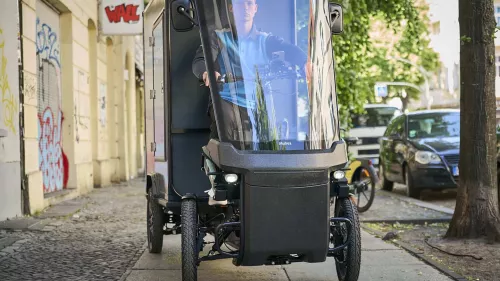 Amazon-Lieferant mit Lastenrad Cargo PACK (von vorne zu sehen) in Berliner Innenstadt